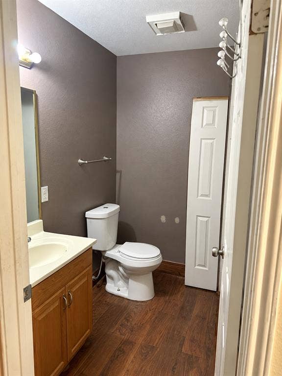 1017 W 3rd Street, Taylor, TX 76574 Clean powder room with a matching wood vanity, framed mirror, and warm interior lighting.