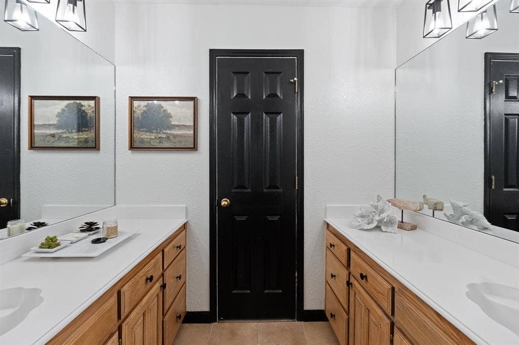 Dual vanity with white countertops and wood-finish cabinetry