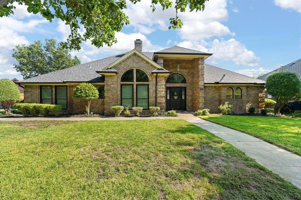 Stone facade with arch-top windows and a dark-toned entry door