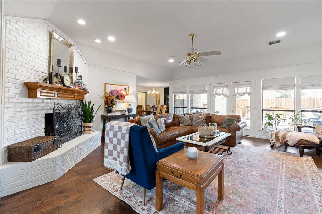 Wood flooring throughout, complemented by a white brick fireplace with a wood mantle