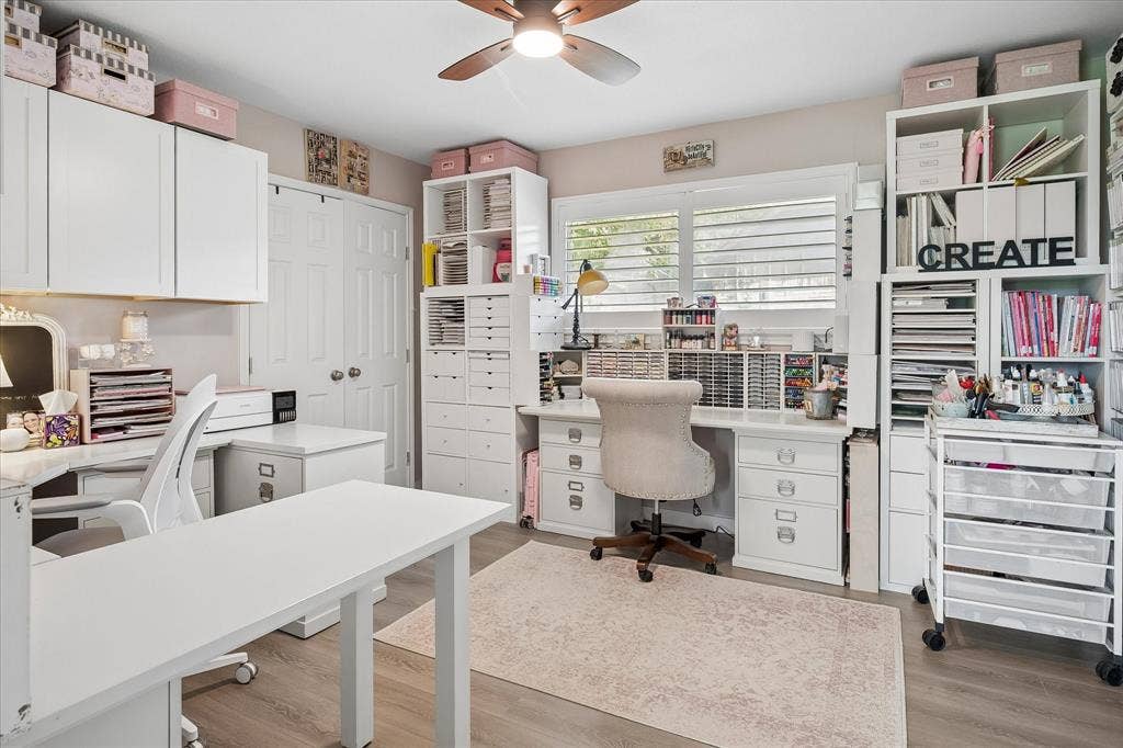 10102 Laingtree Drive, Dallas, TX 75243 Custom built-in white cabinetry, integrated desk workspace, wood-finish flooring, ceiling fan, and window shutters