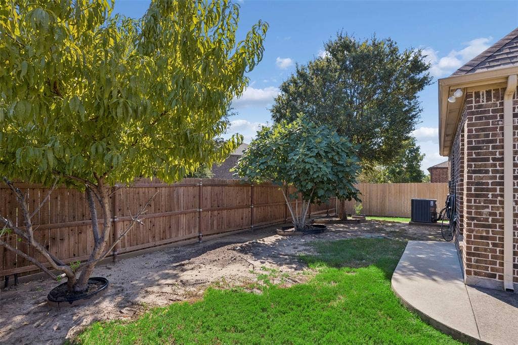901 Memory Lane, McKinney, TX 75072 Fenced backyard with mature trees, a concrete pathway, and a brick exterior