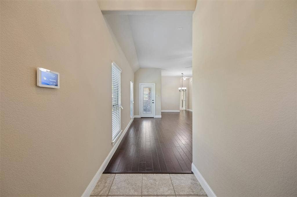901 Memory Lane, McKinney, TX 75072 Tile flooring entryway with engineered wood-finish flooring extending into the main area, vaulted ceilings, and a smart thermostat