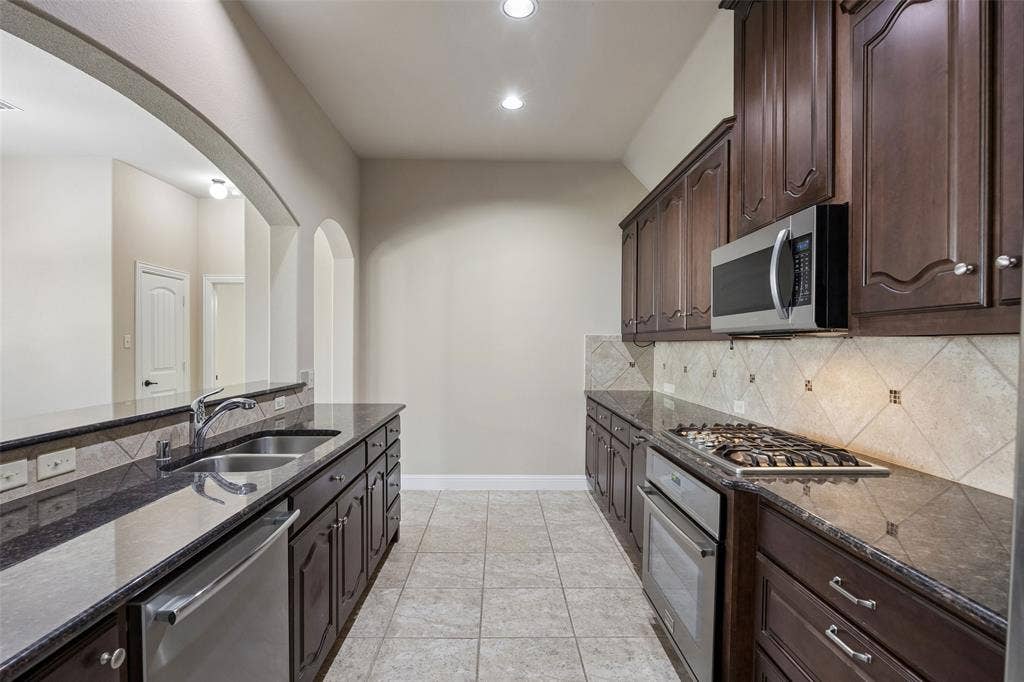 901 Memory Lane, McKinney, TX 75072 Dark wood cabinetry, stainless steel appliances, granite countertops, gas cooktop, pot drawers