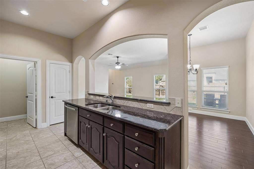 901 Memory Lane, McKinney, TX 75072 Granite countertops, dark wood-finish cabinetry, and stainless dishwasher