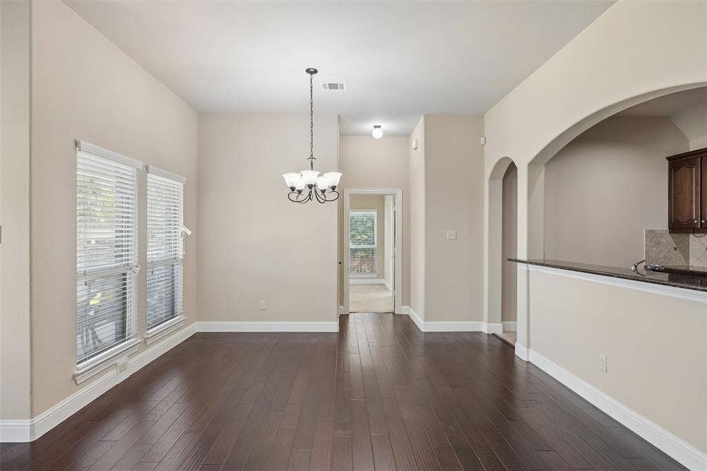901 Memory Lane, McKinney, TX 75072 High ceilings, dark wood-finish flooring, two large windows with blinds, arched architectural elements