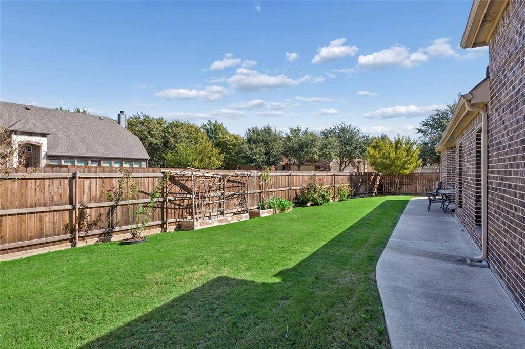 901 Memory Lane, McKinney, TX 75072 Expansive backyard featuring a manicured lawn, wood privacy fence, and concrete patio