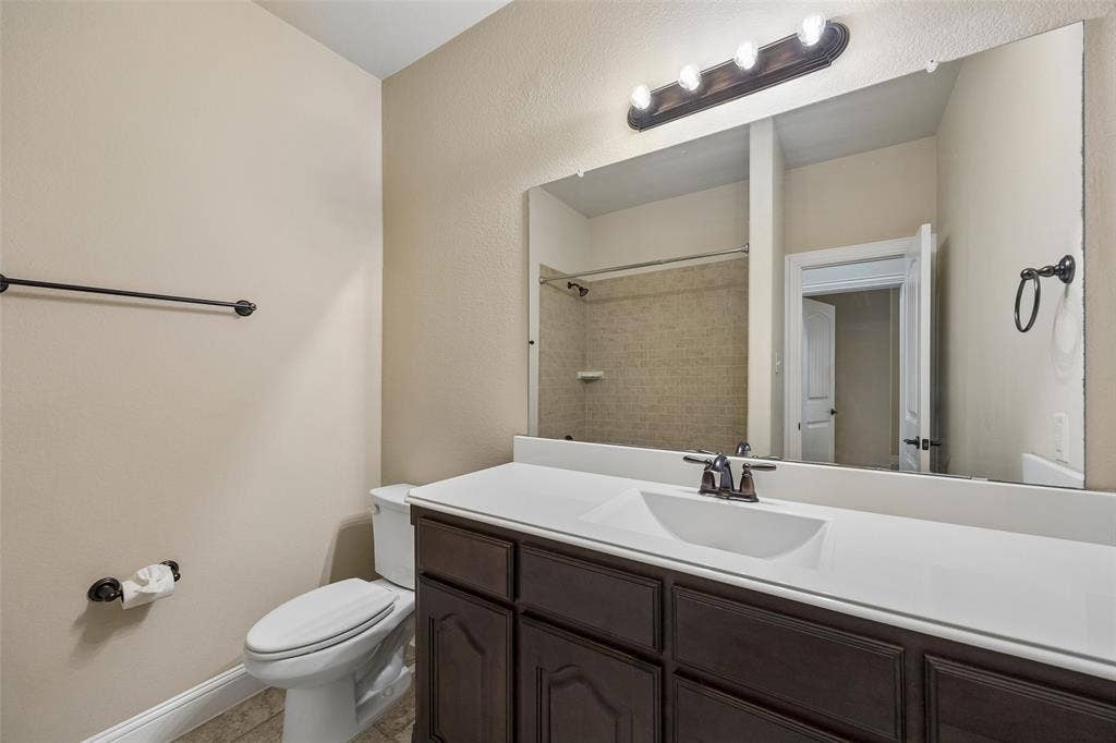 901 Memory Lane, McKinney, TX 75072 Dark wood-finish vanity with white countertop and integrated sink