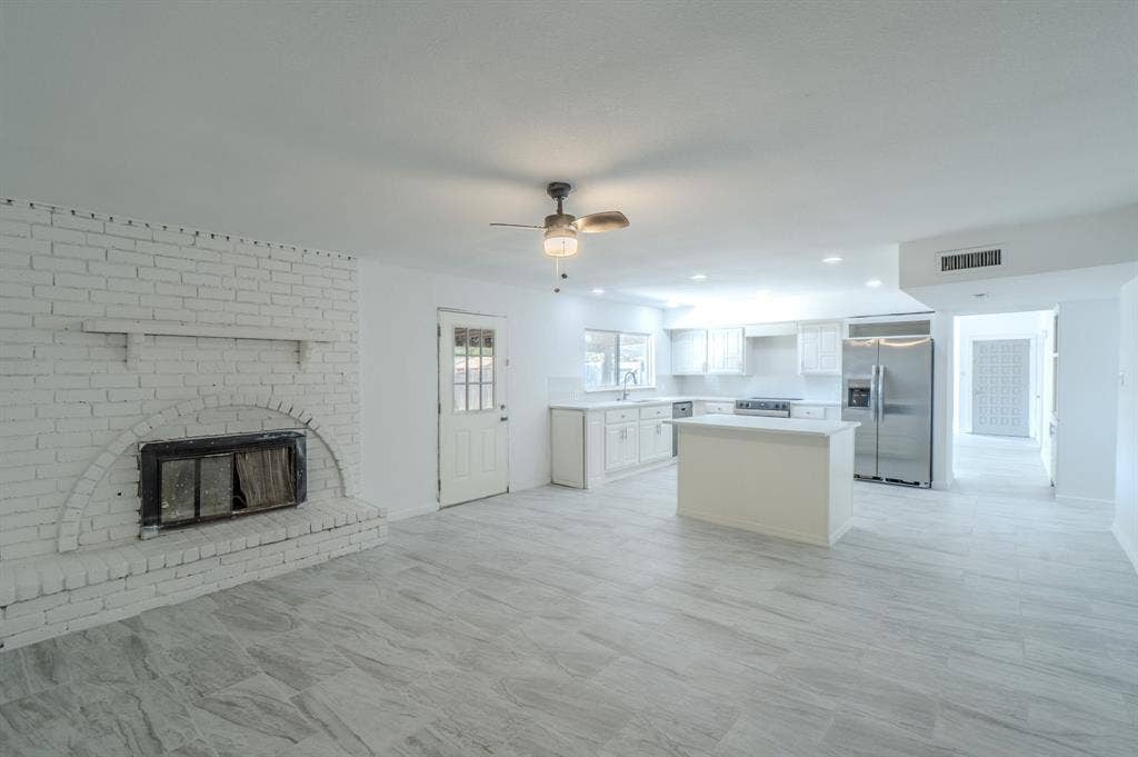 4312 Woodbluff Drive, Mesquite, TX 75150 Open-concept living space featuring a white brick fireplace, tile flooring, and a ceiling fan
