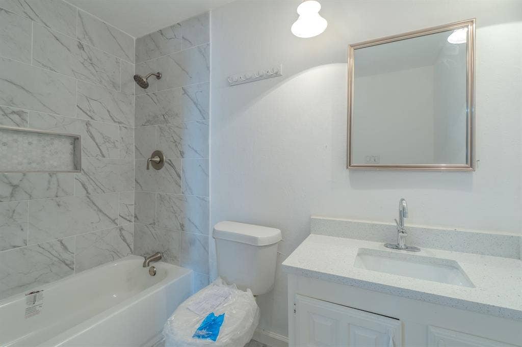 4312 Woodbluff Drive, Mesquite, TX 75150 Tub-shower combination featuring large format wall tile with a decorative recessed niche