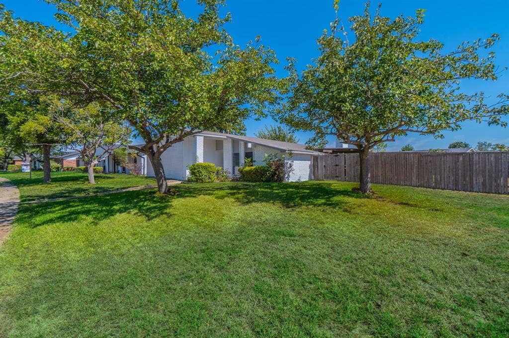 4312 Woodbluff Drive, Mesquite, TX 75150 Expansive lawn with mature trees and privacy fencing