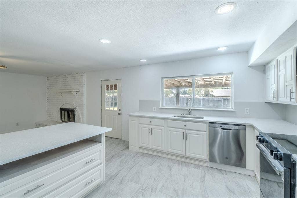 4312 Woodbluff Drive, Mesquite, TX 75150 Recessed lighting, white shaker-style cabinetry, stainless steel dishwasher, white countertops, and wood-finish flooring