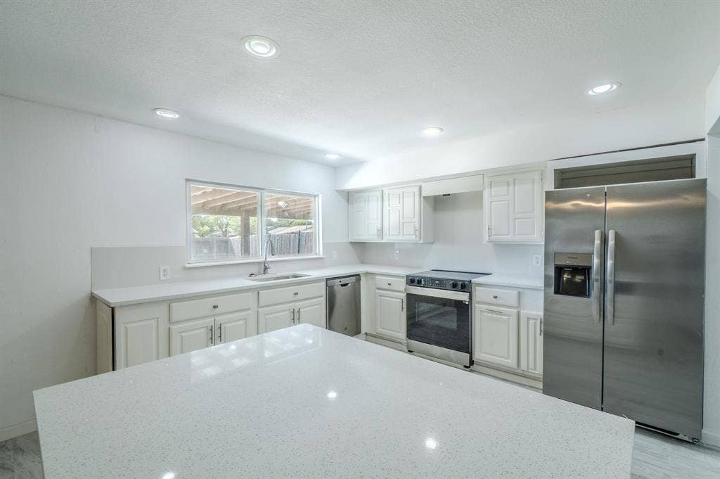 4312 Woodbluff Drive, Mesquite, TX 75150 Kitchen featuring white cabinetry, light-toned countertops, recessed lighting, and stainless steel appliances