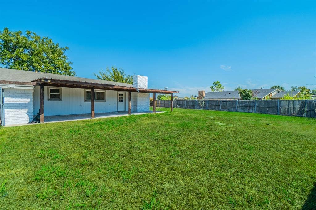 4312 Woodbluff Drive, Mesquite, TX 75150 Spacious backyard featuring a covered patio, expansive lawn, and full perimeter fencing
