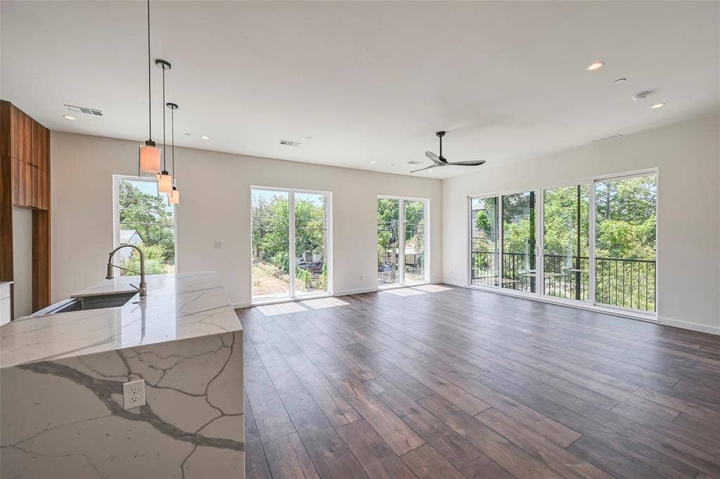 2247 Mail Avenue, #103, Dallas, TX 75235 Open-concept living space featuring wood-finish flooring, recessed lighting, a ceiling fan, and large sliding glass doors leading to balconies