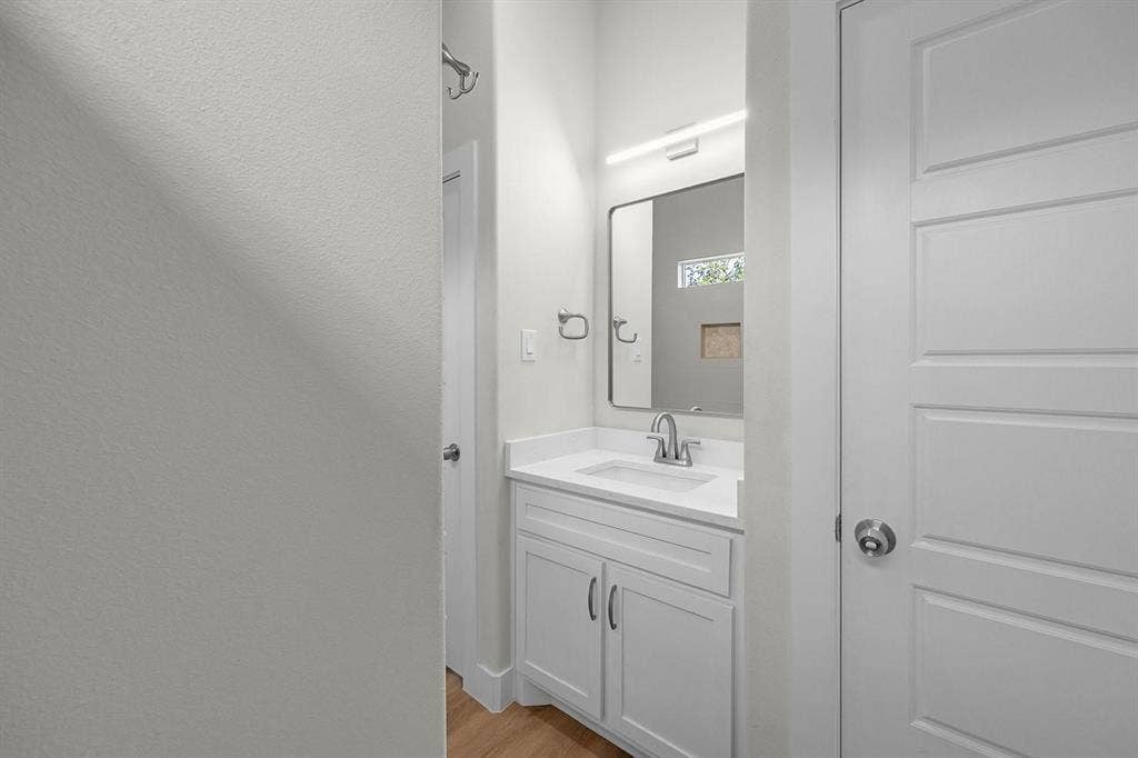 5511 Black Pine Circle, Granbury, TX 76048 Bathroom vanity with white cabinetry, integrated sink, and chrome faucet