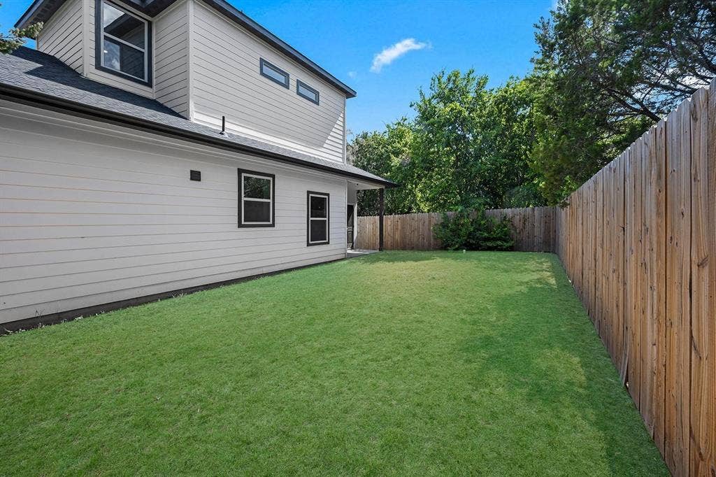 5511 Black Pine Circle, Granbury, TX 76048 Expansive grass lawn with a tall wood privacy fence