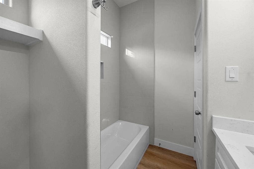 5511 Black Pine Circle, Granbury, TX 76048 Bathtub with tile surround, built-in shelving, and transom window