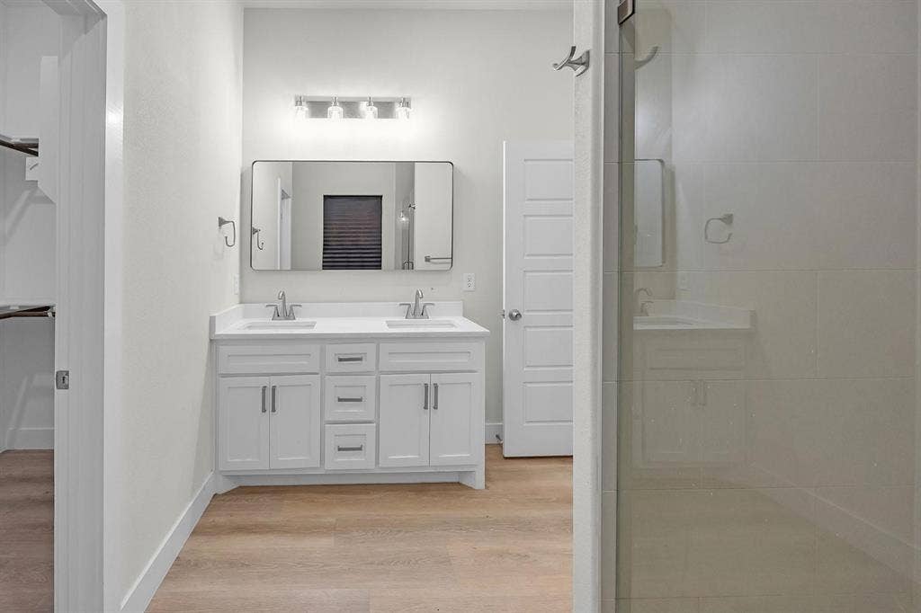 5511 Black Pine Circle, Granbury, TX 76048 Dual vanity with white shaker-style cabinetry, chrome hardware, and undermount sinks
