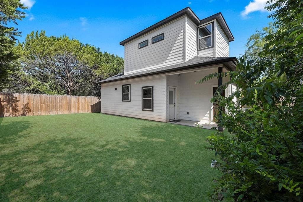 5511 Black Pine Circle, Granbury, TX 76048 Expansive green lawn, wood fence, white siding, and covered patio