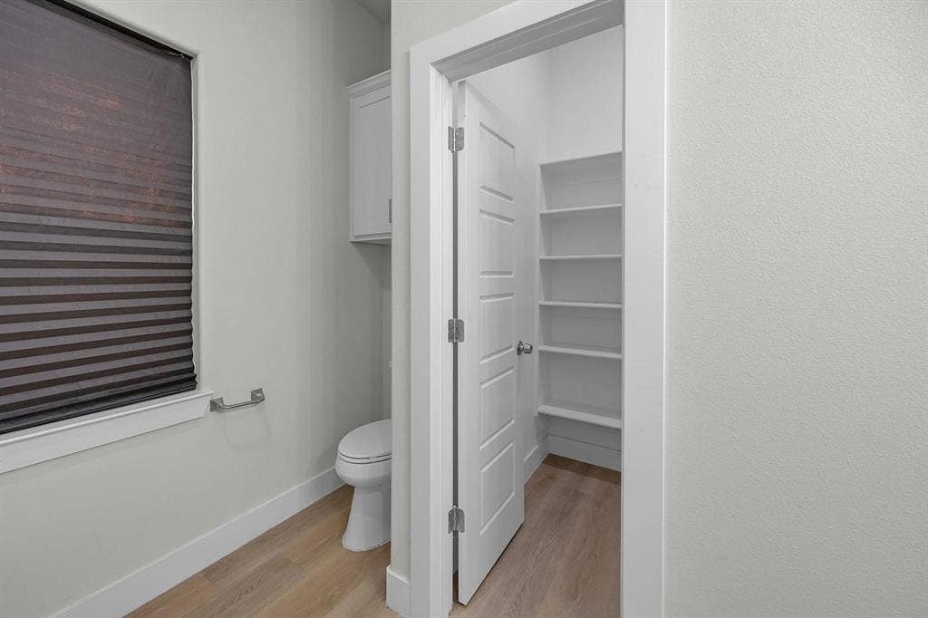 5511 Black Pine Circle, Granbury, TX 76048 Window with horizontal blinds, built-in wall cabinet, and a water closet