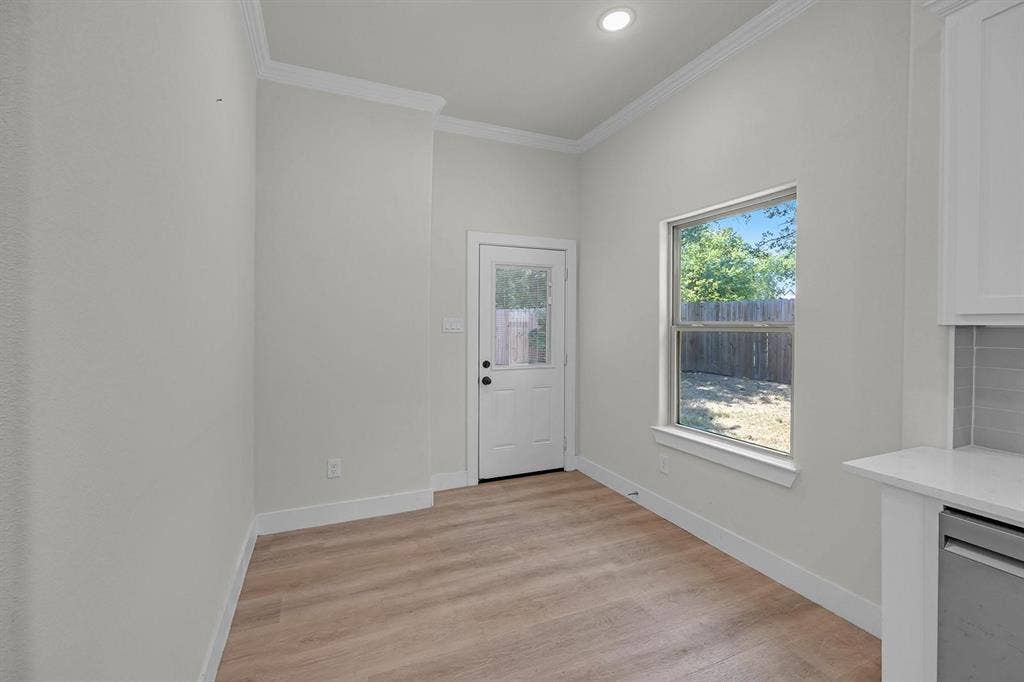 5511 Black Pine Circle, Granbury, TX 76048 Wood-finish flooring, recessed lighting, crown molding, white trim, and a white paneled door