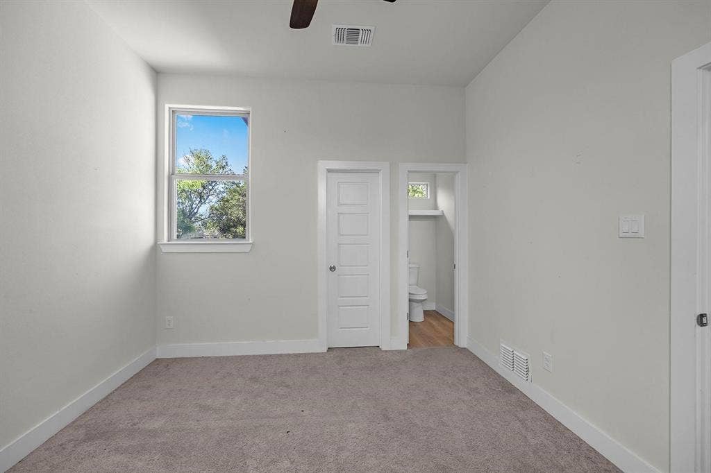 5511 Black Pine Circle, Granbury, TX 76048 Carpeted room featuring a single window, a ceiling fan, and two interior doors