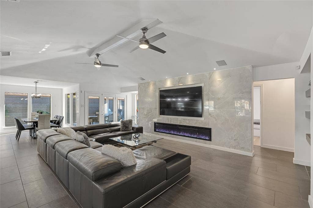 6802 Duffield Drive, Dallas, TX 75248 Vaulted ceilings with recessed lighting, tile flooring, and a linear electric fireplace integrated into a floor-to-ceiling tile accent wall