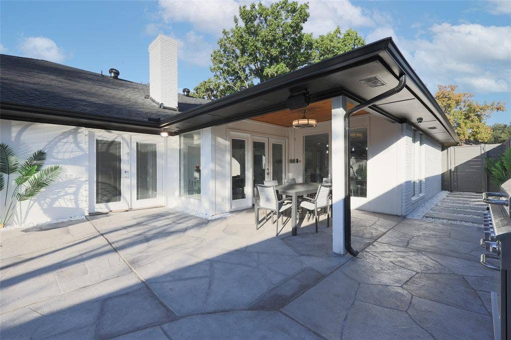 6802 Duffield Drive, Dallas, TX 75248 Expansive patio featuring stamped concrete, a covered section with wood-finish ceiling, and multiple access points to the interior