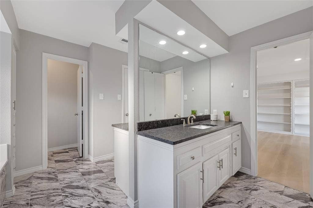 6802 Duffield Drive, Dallas, TX 75248 White vanity with a dark countertop and integrated sink