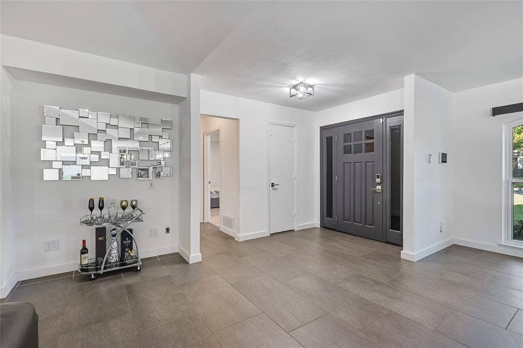 6802 Duffield Drive, Dallas, TX 75248 Entryway featuring a Craftsman-style door with sidelights, overhead lighting, wood-finish flooring, and white trim