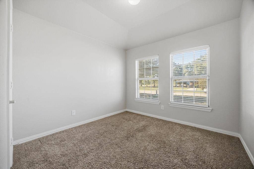 408 Northgate Drive, Terrell, TX 75160 Vaulted ceiling, two windows with blinds, carpet flooring, and neutral wall paint