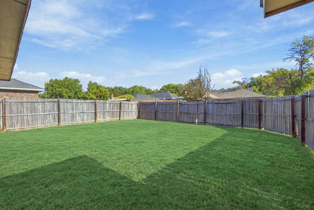 408 Northgate Drive, Terrell, TX 75160 Expansive green lawn with a full perimeter wood fence