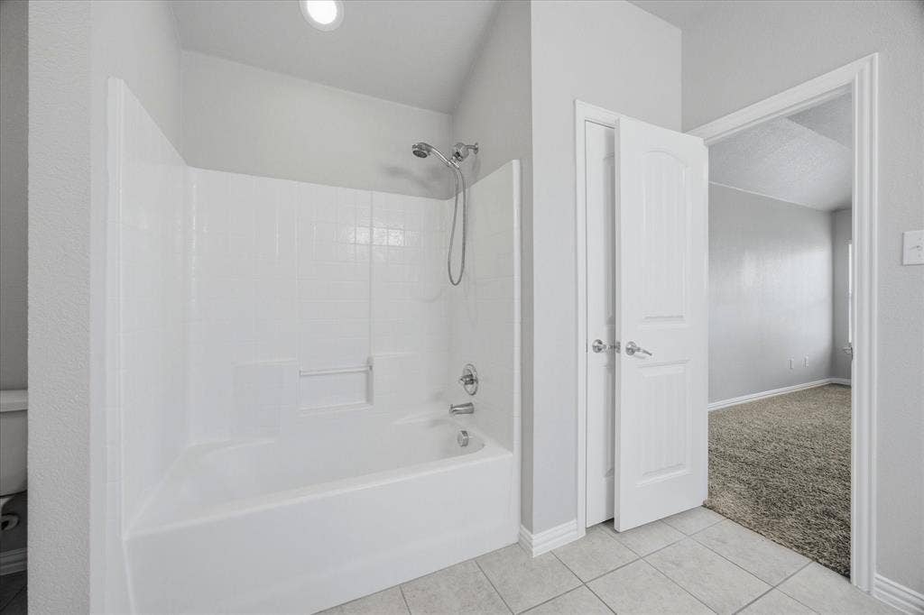 408 Northgate Drive, Terrell, TX 75160 White tub and shower combination with a fixed showerhead and handheld sprayer, set against a light gray wall