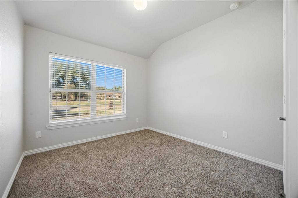408 Northgate Drive, Terrell, TX 75160 Neutral wall color, vaulted ceiling, recessed lighting, carpet flooring, and a large window with horizontal blinds