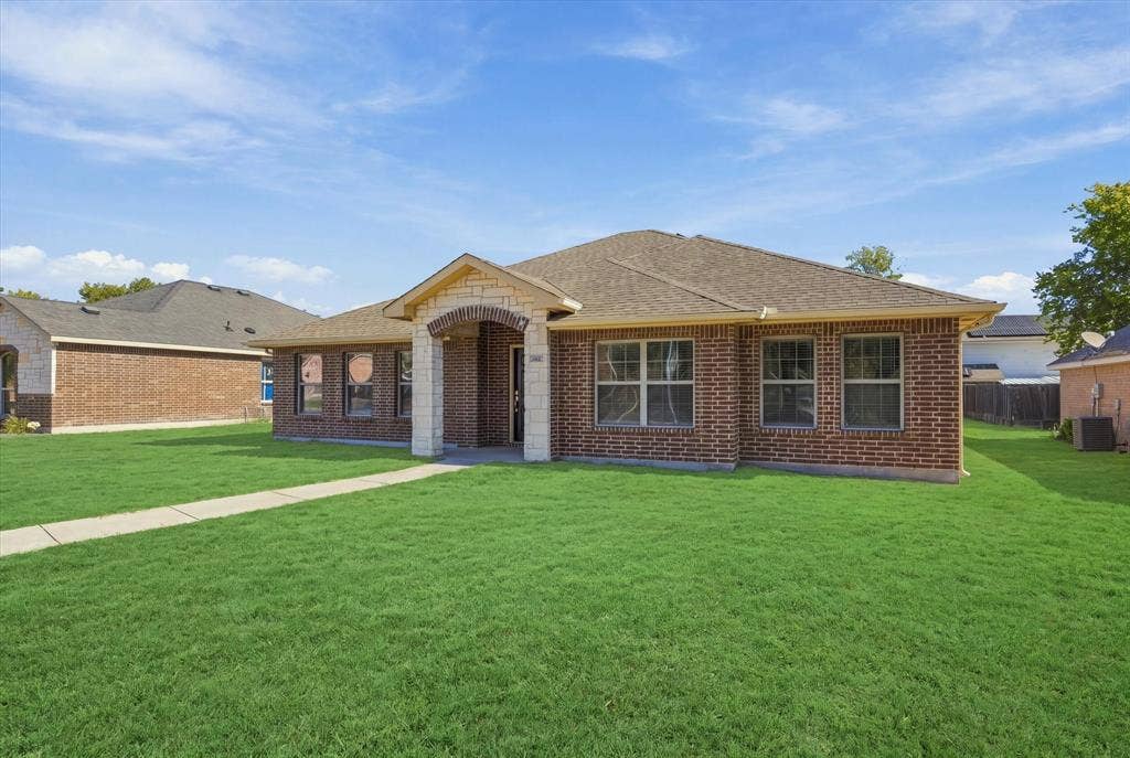 408 Northgate Drive, Terrell, TX 75160 Brick exterior with stone accents, covered entry, multiple windows, and a paved walkway