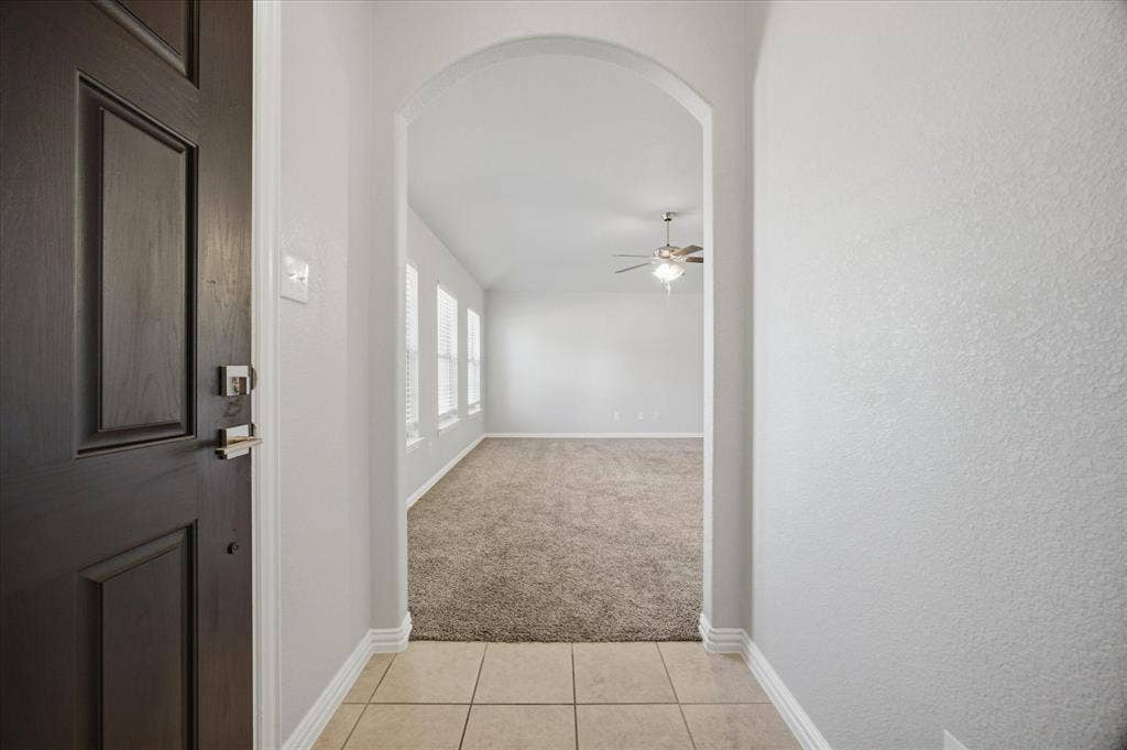 408 Northgate Drive, Terrell, TX 75160 Bright hallway with arched entryway, ceramic tile flooring, and ceiling fan