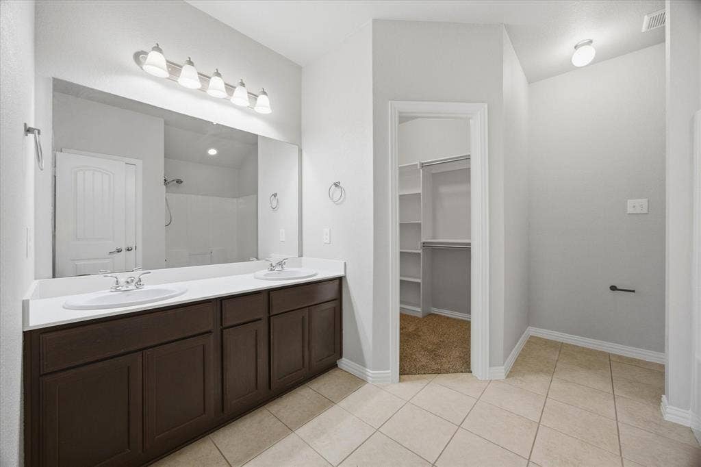 408 Northgate Drive, Terrell, TX 75160 Dual vanity with white countertops, integrated sinks, and brown cabinetry