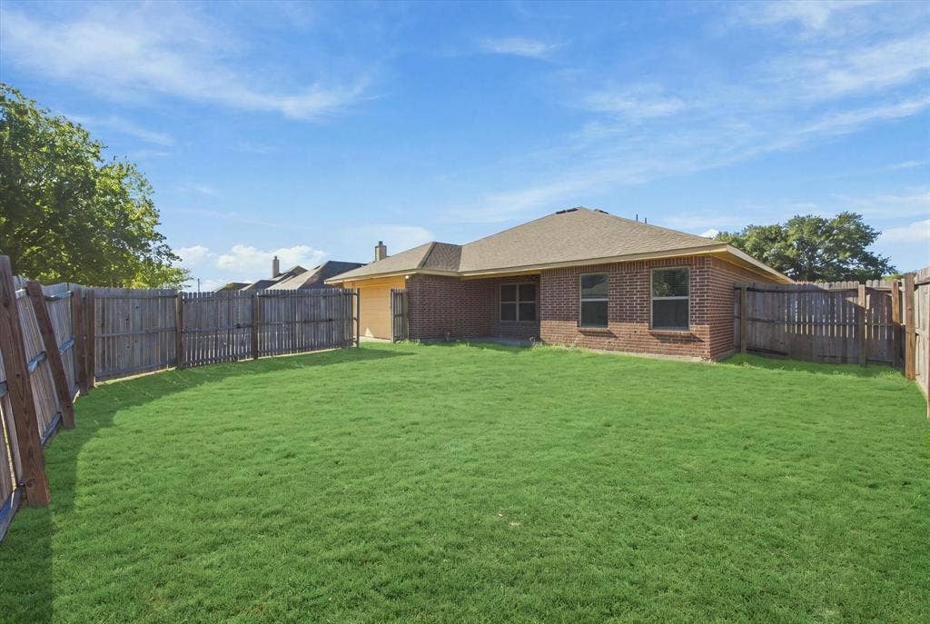 408 Northgate Drive, Terrell, TX 75160 Expansive backyard featuring a brick exterior, shingle roof, and a wood fence