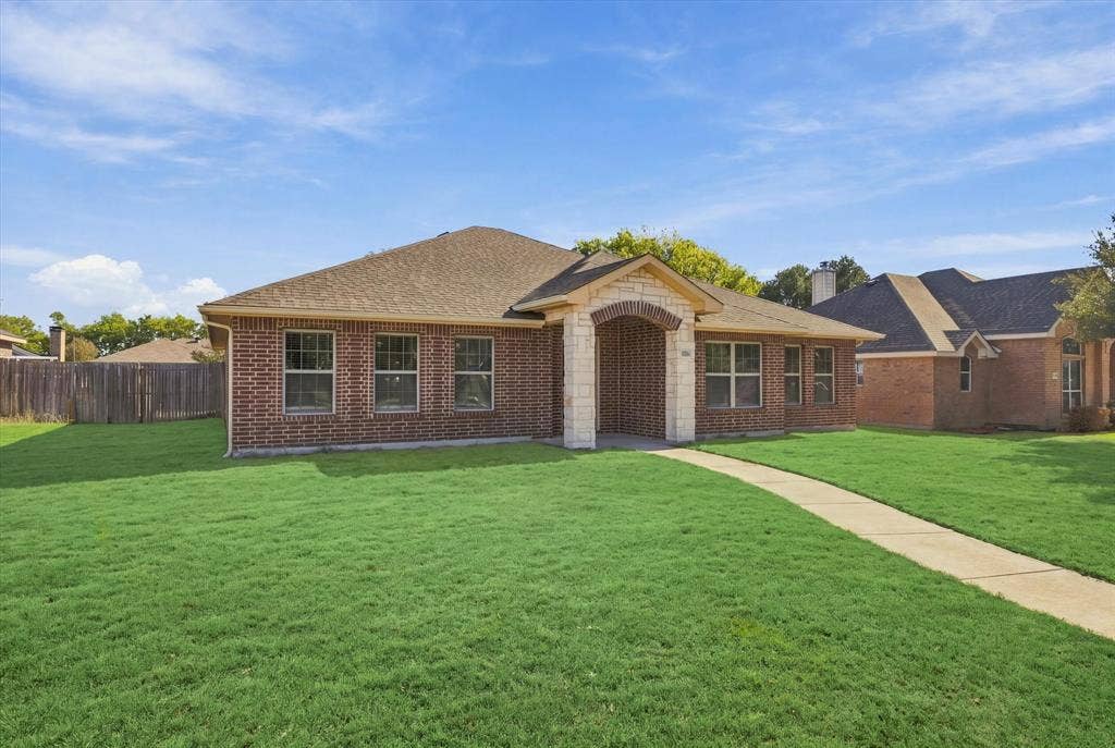 408 Northgate Drive, Terrell, TX 75160 Brick exterior with stone accents, a gabled roof, and a concrete pathway