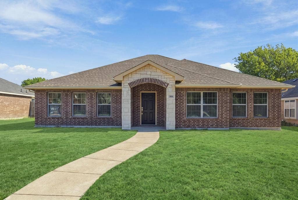 408 Northgate Drive, Terrell, TX 75160 Brick exterior with stone accents, a gabled roof, and a concrete walkway