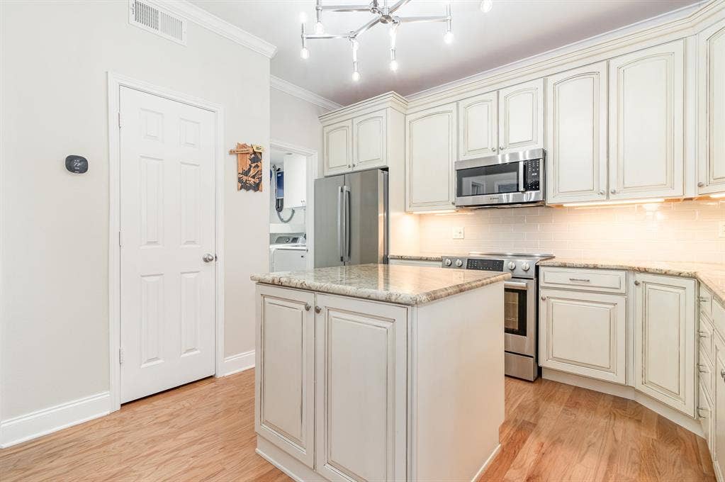 2800 Keller Springs Road, #8C, Carrollton, TX 75006 Full-size utility room off kitchen to the left of fridge provides efficient location.