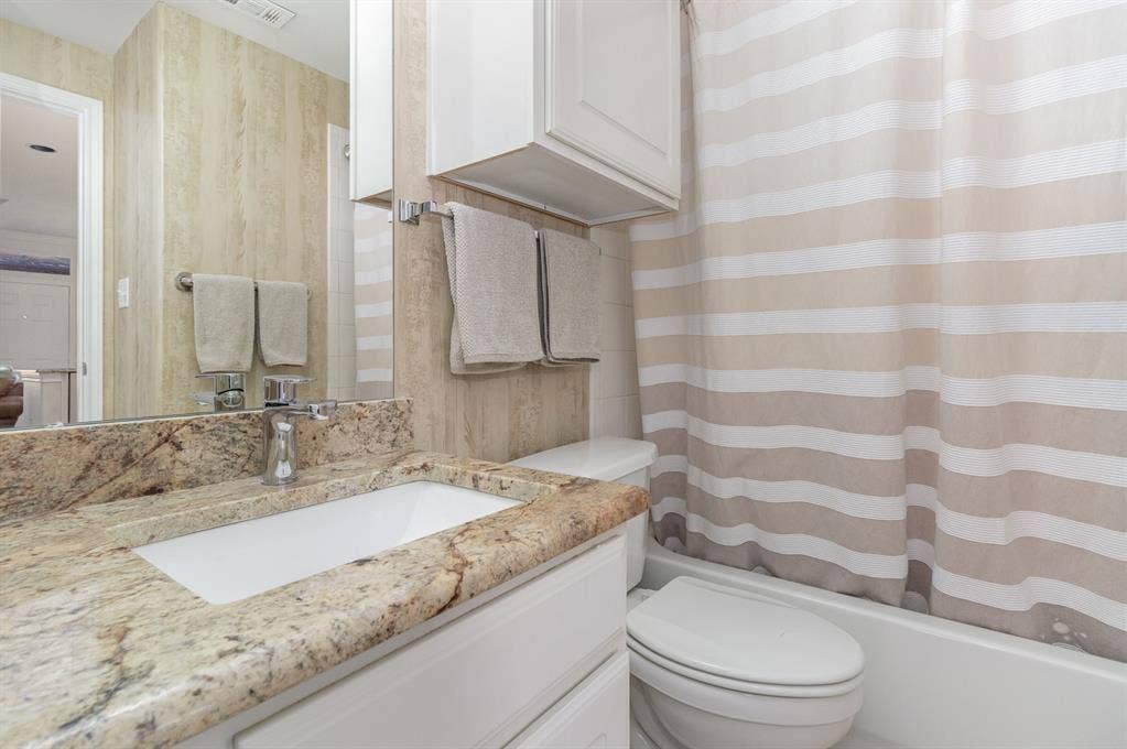 2800 Keller Springs Road, #8C, Carrollton, TX 75006 First floor full bath with granite counters, built-in cabinet, tub-shower combination.