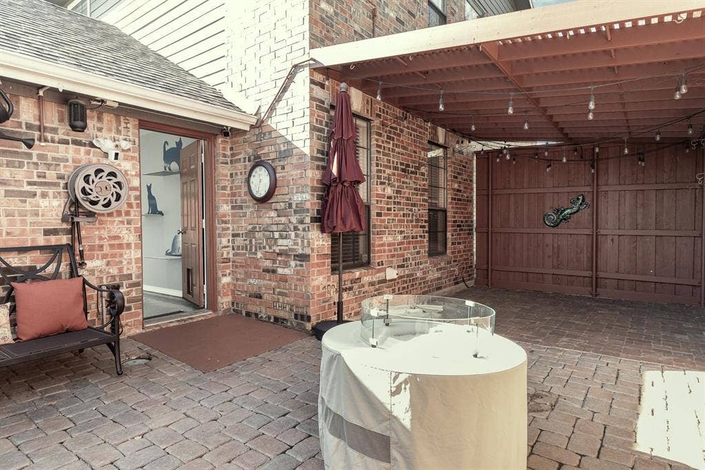 2800 Keller Springs Road, #8C, Carrollton, TX 75006 Side yard has brick paving (low maintenance), is partially covered, has fire pit, water feature and awning.