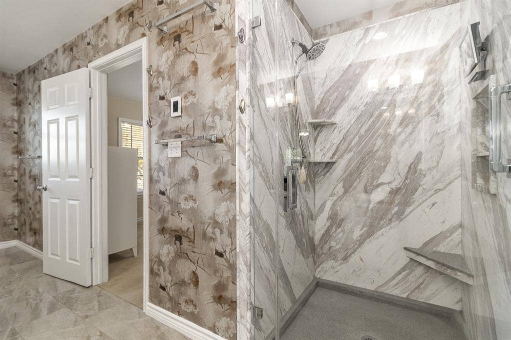 2800 Keller Springs Road, #8C, Carrollton, TX 75006 Seamless glass walk-in shower has been custom-designed with inset shelving, foot rest, additional corner shelving and magnetic rain-shower head.