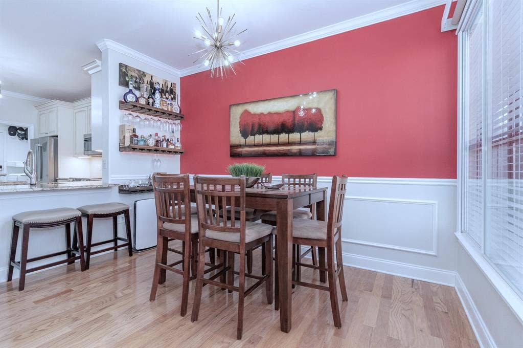 2800 Keller Springs Road, #8C, Carrollton, TX 75006 Dining area with built-in shelving, wainscoting and picture frame paneling. Crown-molding accents. Designer light fixture.