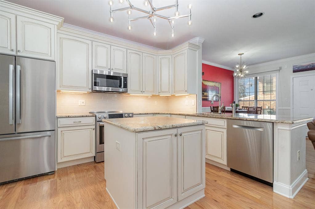 2800 Keller Springs Road, #8C, Carrollton, TX 75006 Kitchen has central island (with power), custom light fixture, recessed LED lighting, 42" cabinets, granite counters.