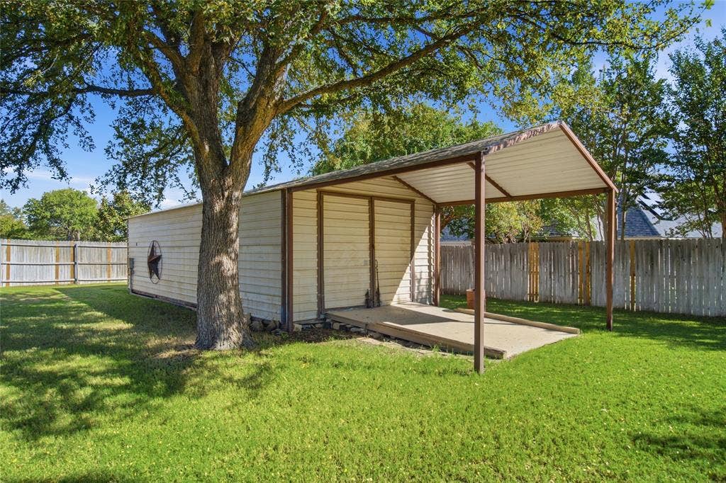 Detached metal structure featuring a covered carport.