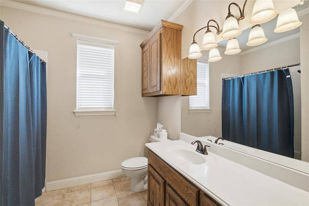 Room featuring wood-finish flooring, crown molding, and a central ceiling fan with integrated lighting