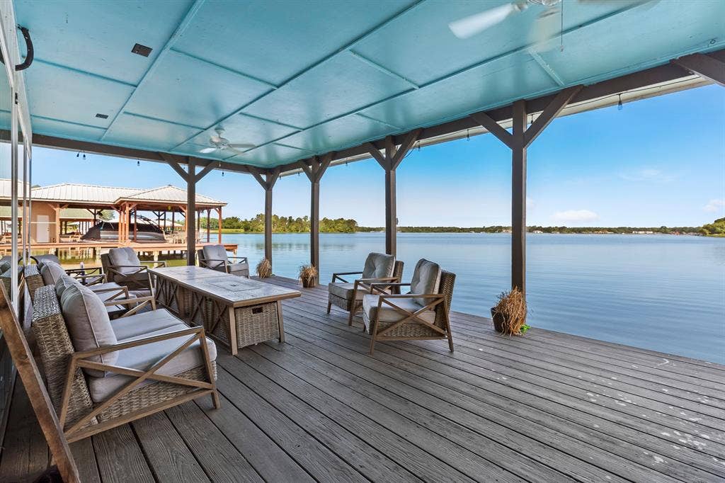 18630 Eastside Road, Troup, TX 75789 Covered outdoor deck with exposed support beams, ceiling fans, and a broad water backdrop